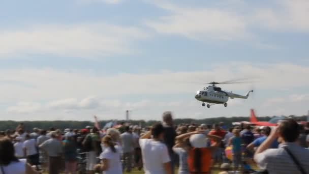Pessoas no terreno a ver o helicóptero a aterrar — Vídeo de Stock
