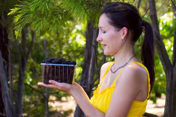 Mujer mirando boysenberries — Foto de Stock