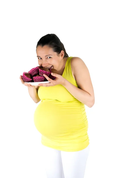 Pregnant woman eating muffins — Stock Photo, Image