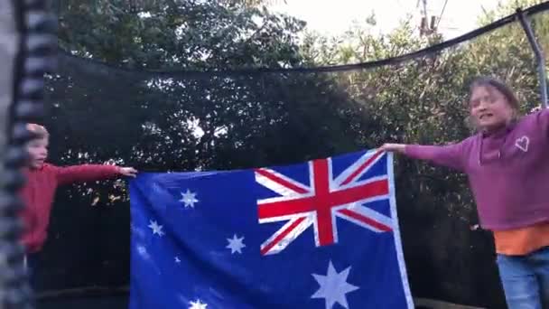 Kinderen springen met Australische vlag op trampoline. — Stockvideo