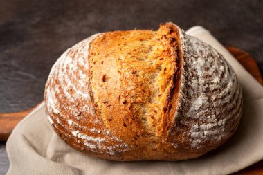 Kahverengi doğrama tahtasındaki keten kumaşa ekşi ekmek..