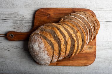 Tahta üzerinde dilimlenmiş ekşi ekmek. Sıcak ruh hali fotoğrafı.. 