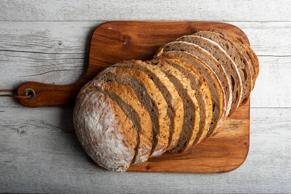 Tahta üzerinde dilimlenmiş ekşi ekmek. Sıcak ruh hali fotoğrafı.. 
