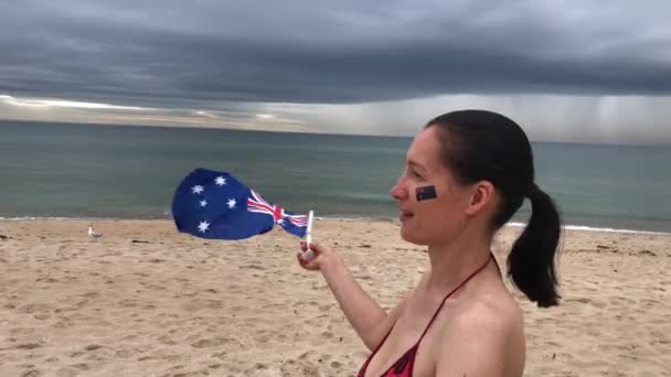 Smiling woman waving two Australian flags. Australia day concept. Slow motion. — Stock Video