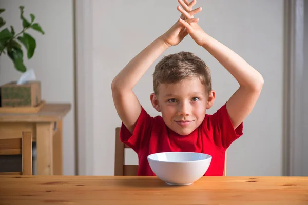 Leuke jongen die bij het ontbijt met granola speelt. Echte uitdrukkingen. — Stockfoto