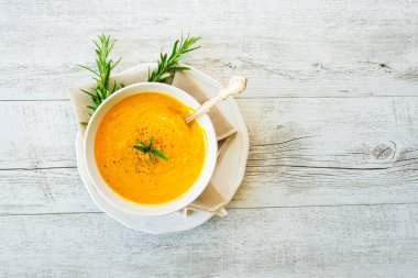 Arka planda keten peçeteli balkabağı çorbası.