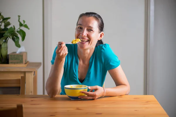 Gülümseyen kadın kahvaltı niyetine Kitchari yiyor.. — Stok fotoğraf