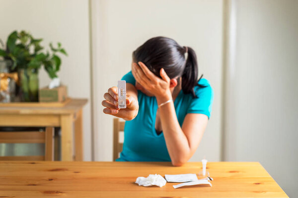 Быстрый тест на антиген дома. Шаг 8. Плачущая женщина показывает положительные результаты теста на антиген. 