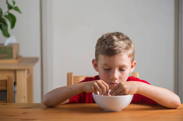 Το χαριτωμένο αγόρι τρώει γκρανόλα για πρωινό. Πορτρέτο τρόπου ζωής. — Φωτογραφία Αρχείου