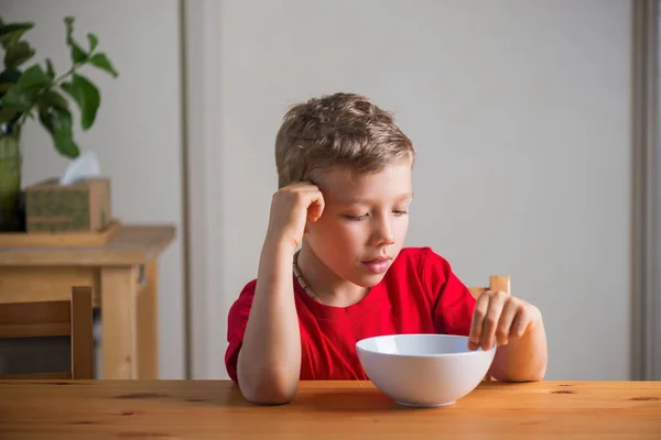 Söt pojke äter granola till frukost. Livsstilsporträtt. — Stockfoto