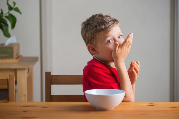 Söt pojke äter granola till frukost. Livsstilsporträtt. — Stockfoto