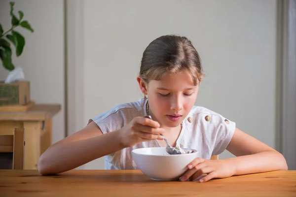 Blond tienermeisje dat ontbijtgranen eet. Lifestyle portret. — Stockfoto