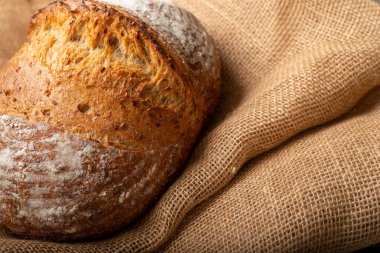 Çuval bezinde izole edilmiş ekşi ekmek. - Yakın çekim. Sıcak ruh hali fotoğrafı. Sağlıklı gıda kavramı.