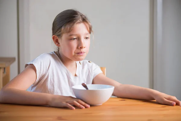 Blond tienermeisje dat ontbijtgranen eet. Lifestyle portret. — Stockfoto