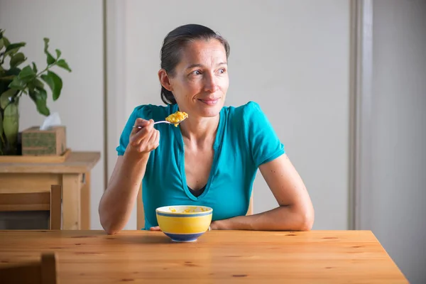 Gülümseyen kadın kahvaltı niyetine Kitchari yiyor.. — Stok fotoğraf