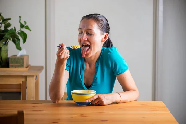 Kahvaltı niyetine Kitchari yiyen ve komik suratlar yapan bir kadın.. — Stok fotoğraf