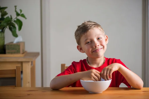 Lachende jongen eet granola als ontbijt. Echte uitdrukkingen. — Stockfoto