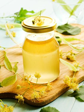 Linden Basswood ağacı balı çay. Tahtada çiçekler var. Sığ dof.