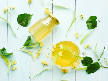 Linden Basswood ağacı balı çay. Tahtada çiçekler var. Sığ dof.