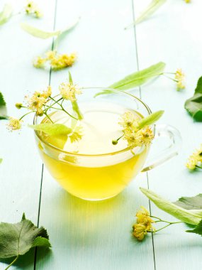 Linden Basswood ağacı balı çay. Tahtada çiçekler var. Sığ dof.