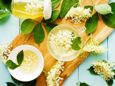 Elderberry şurubu tahtanın üzerinde çiçekler olan ev yapımı bal. Sığ dof.