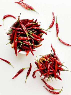 Beyaz arka plandaki bir kasede kurutulmuş kırmızı kırmızı kırmızı biber. Sığ dof.