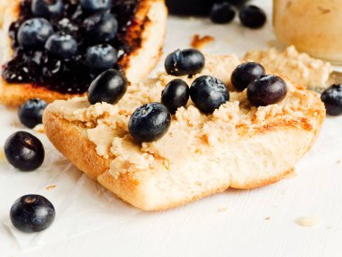 Fıstık ezmeli ve yabanmersinli beyaz ekmek tostu. Sığ dof.