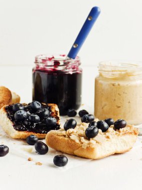 Yaban mersini reçeli ve fıstık ezmeli beyaz ekmek tostu. Sığ dof.