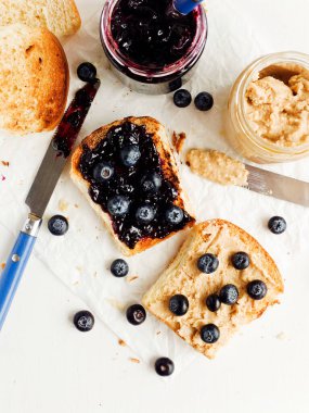 Yaban mersini reçeli ve fıstık ezmeli beyaz ekmek tostu. Sığ dof.