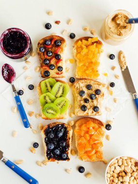 Meyveli, böğürtlenli, reçelli ve fıstık ezmeli beyaz ekmek. Sığ dof.