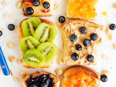 Meyveli, böğürtlenli, reçelli ve fıstık ezmeli beyaz ekmek. Sığ dof.