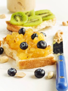 Meyveli, böğürtlenli, reçelli ve fıstık ezmeli beyaz ekmek. Sığ dof.