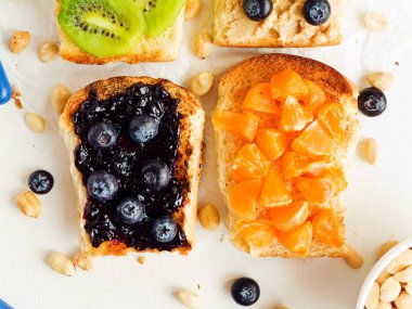 Meyveli, böğürtlenli, reçelli ve fıstık ezmeli beyaz ekmek. Sığ dof.