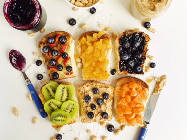 Meyveli, böğürtlenli, reçelli ve fıstık ezmeli beyaz ekmek. Sığ dof.