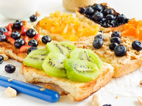 Meyveli, böğürtlenli, reçelli ve fıstık ezmeli beyaz ekmek. Sığ dof.