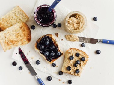 Yaban mersini reçeli ve fıstık ezmeli beyaz ekmek tostu. Sığ dof.