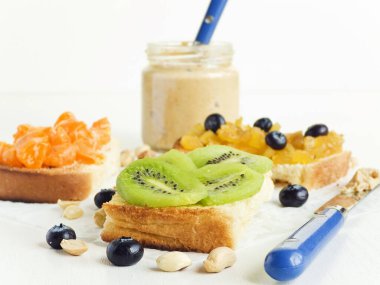 Meyveli, böğürtlenli, reçelli ve fıstık ezmeli beyaz ekmek. Sığ dof.