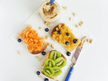 Meyveli, böğürtlenli, reçelli ve fıstık ezmeli beyaz ekmek. Sığ dof.