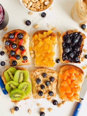 Meyveli, böğürtlenli, reçelli ve fıstık ezmeli beyaz ekmek. Sığ dof.