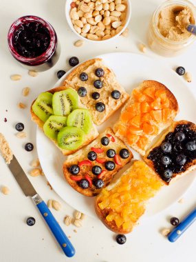 Meyveli, böğürtlenli, reçelli ve fıstık ezmeli beyaz ekmek. Sığ dof.