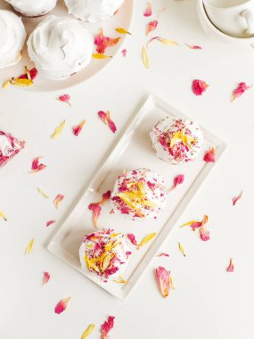 Krem şantili ve yenilebilir çiçekli kekler. Sığ dof.