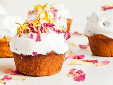 Krem şantili ve yenilebilir çiçekli kekler. Sığ dof.