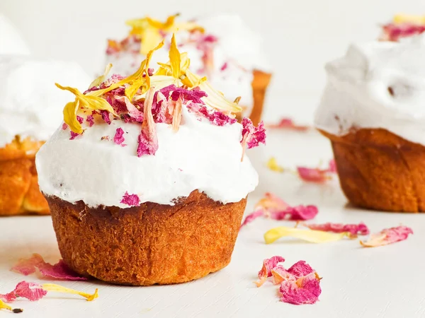 Krem şantili ve yenilebilir çiçekli kekler. Sığ dof.