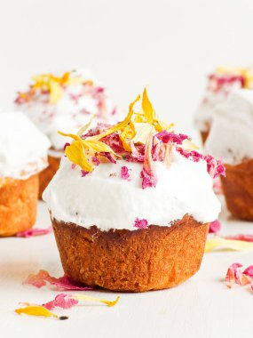 Krem şantili ve yenilebilir çiçekli kekler. Sığ dof.