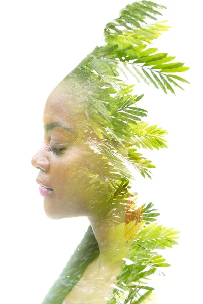Retrato de una mujer afroamericana combinado con una imagen de follaje verde en una técnica de doble exposición. — Foto de Stock