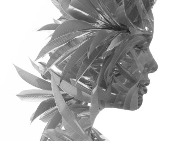 Çift pozlama tekniğinde yapraklarla birleştirilmiş siyah beyaz bir kadın portresi.