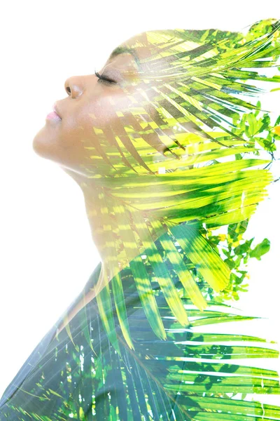 Профильный портрет женщины в сочетании с тропическими листьями в технике двойной экспозиции. — стоковое фото