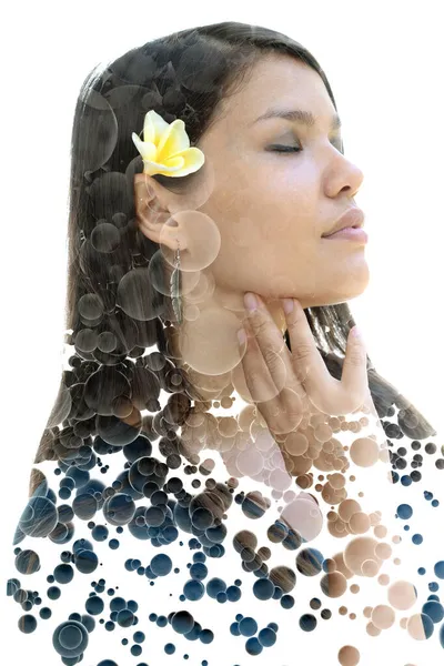 Een portret van een vrouw met bloem in haar gecombineerd met zwevende 3D bollen in een dubbele belichtingstechniek — Stockfoto