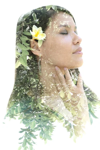 Een portret van een vrouw met een bloem in haar haar gecombineerd met een beeld van de natuur in een dubbele belichtingstechniek — Stockfoto