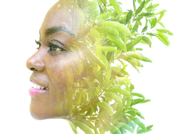 Un retrato de una mujer afroamericana combinado con una imagen de hojas verdes en una técnica de doble exposición. — Foto de Stock